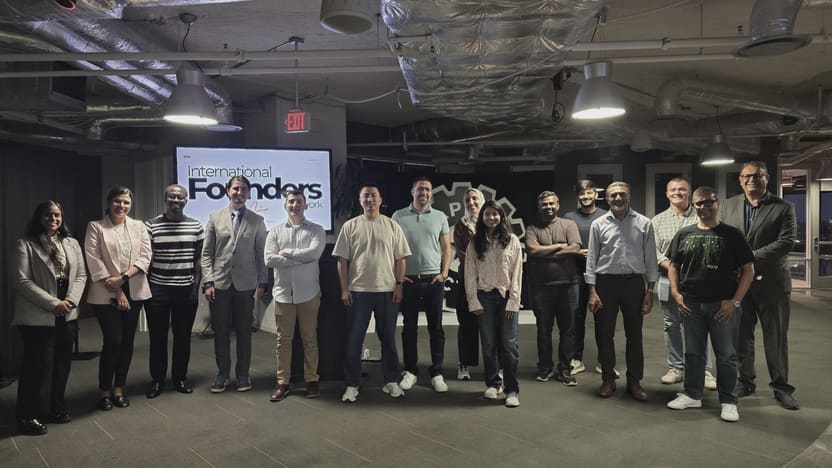 A line of people standing shoulder to shoulder facing the camera in front of an IFN meetup screen at the end of the evening.